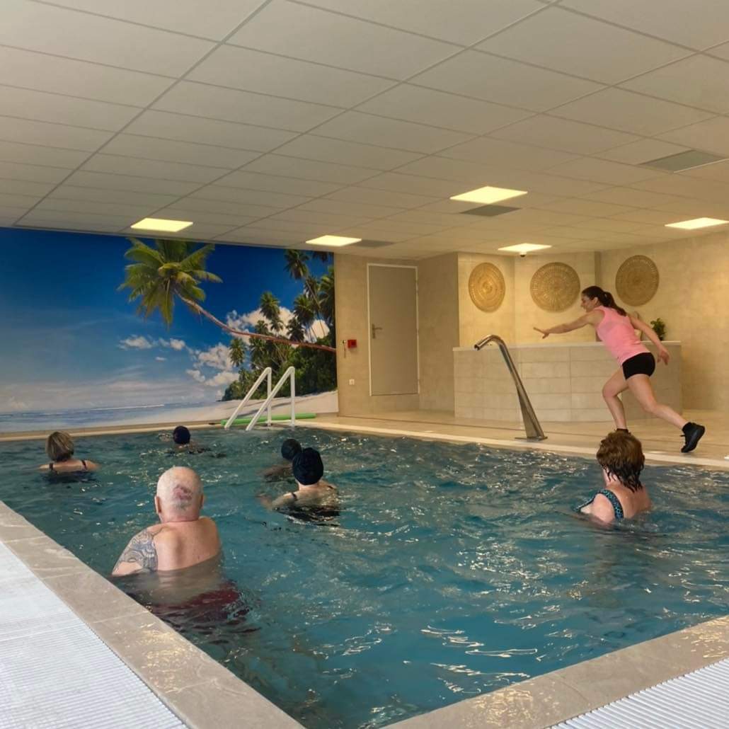 Bassin d'aquagym avec professeure et pratiquants